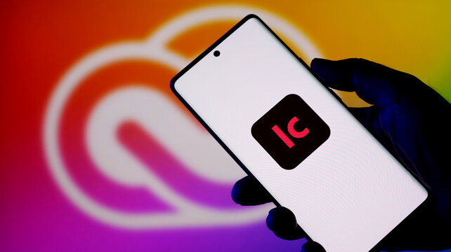 Closeup of a smartphone displaying the adobe incopy app icon against a blurred creative cloud logo background