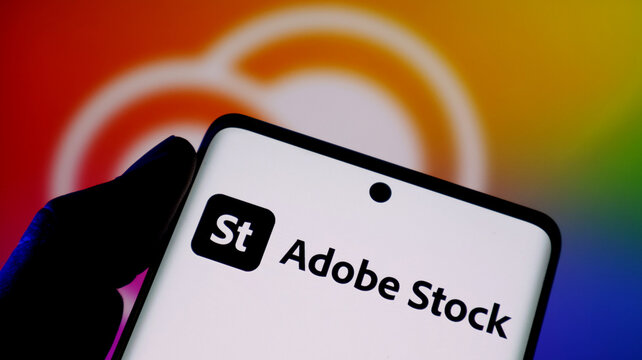 Closeup of a smartphone screen displaying the adobe stock logo and brand name