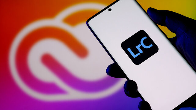 Smartphone displaying the adobe lightroom classic logo with creative cloud background