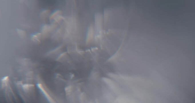 Abstract silver blurry background with moving lens flares and refractions. Delicate colors bokeh effect for luxury logo display. Grey-blue light leaks on a blurred background with copy space. Template