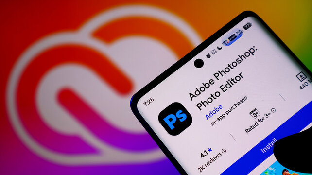 Smartphone displaying the adobe photoshop photo editor app page on the google play store