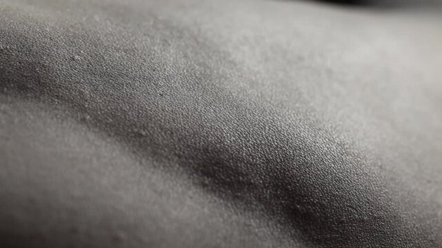 A close-up view of a person's back against a dark, featureless background