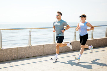 Joyful runners enjoy a sunny morning jog along the beautiful waterfront promenade © muse studio