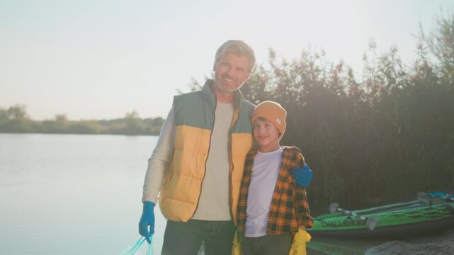 Father and son gather trash, Sunrise cleanup highlights father son teamwork supporting nature preservation