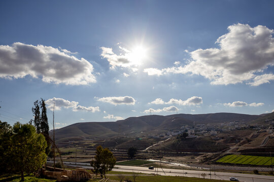 Landscape view of the road leading to Sukhna town in Zarqa Jordan under a sunny morning sky with clouds.