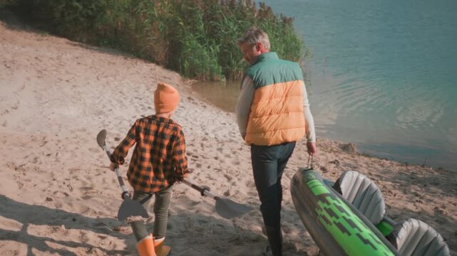 Family kayaking outing, Father and son enjoy peaceful lakeside journey with their colorful kayak and shared joy