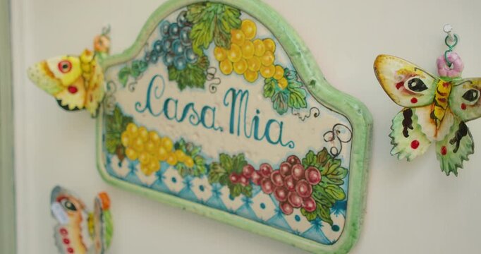 Ceramic Casa Mia sign with colorful grapes and butterflies seen in summer local shop in in Capri Italy