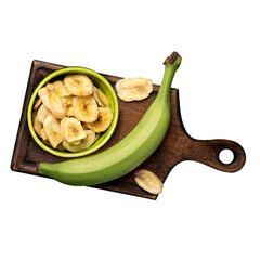 Top-down view of healthy, crispy, crunchy dried banana chips in a green ceramic bowl with a whole green plantain on a rustic wooden cutting board, isolated on a transparent background. © Nabila