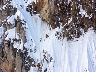 Snow-Covered Rocky Cliff Face With Steep Cornices and Ice in BC, Canada Mountains © edb3_16