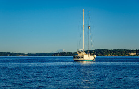 A sail boat in early morning in Puget Sound near Port Townsend, Washington with Mount Rainier in the distance