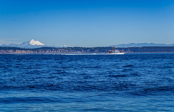 A US Coast Guard ship patrols Puget Sound in Washington state with Mount Baker in the distance