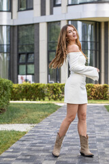 Obraz premium Young beautiful model in a white short dress with long sleeves