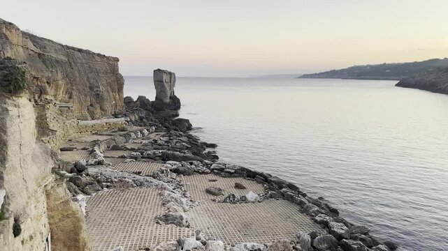 Italy,  Puglia, April 18, 2025.
Beautiful Mediterranean coastal landscape with rocks and calm sea at sunset in Puglia, Italy.
Author: Djundiet A.