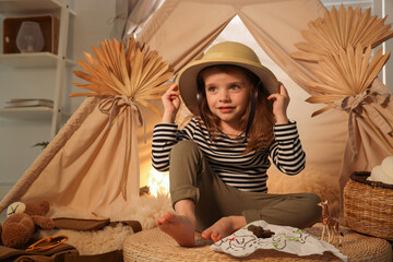 Little girl with drawing of map near wigwam at home. Space for text © New Africa