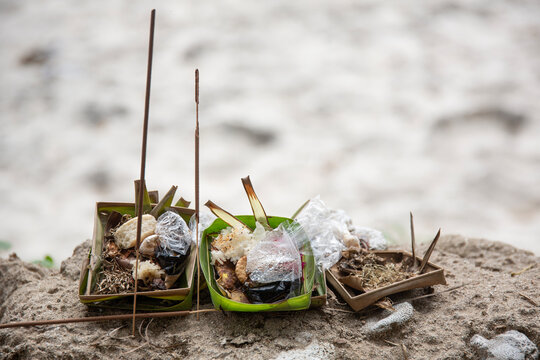 Traditional canang sari offerings on sandy beach in Bali