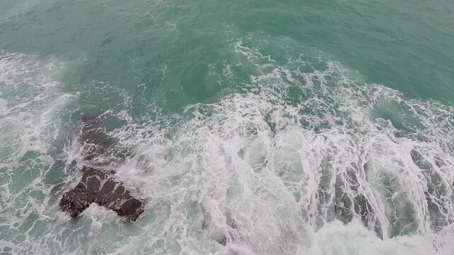 Ocean waves hitting coastal rocks on shoreline