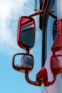 Red truck mirrors gleam against blue sky