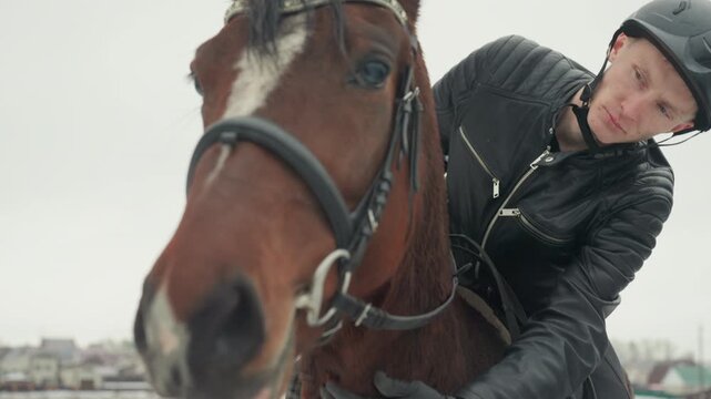 Close bond during winter riding. Connection between rider and steed shown during cold city training. Faithful companionship evident between horse and rider in winter urban equestrian practice