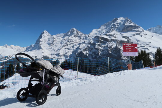 Baby Stroller in Snow at Allmendhubel with Eiger M&ouml;nch Jungfrau Alps, Winter Family Travel Switzerland