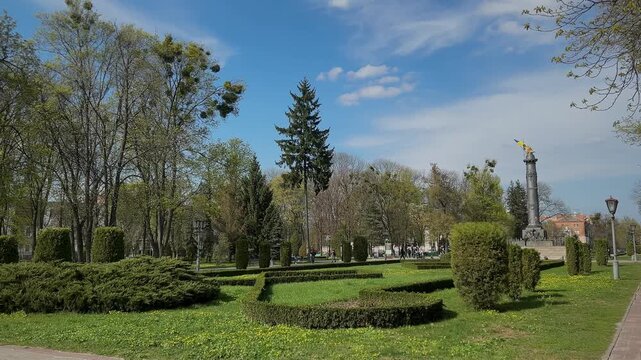 Korpusnyi Park (Korpusnyi Garden) in the center of Poltava city during spring. A scenic view of the central circular park in Poltava, Ukraine, featuring fresh spring greenery, blooming trees, and walk