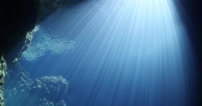 sun rays sun beams and sun shine underwater in cave beautiful light scenery in ocean scuba divers to see in cave backgrounds