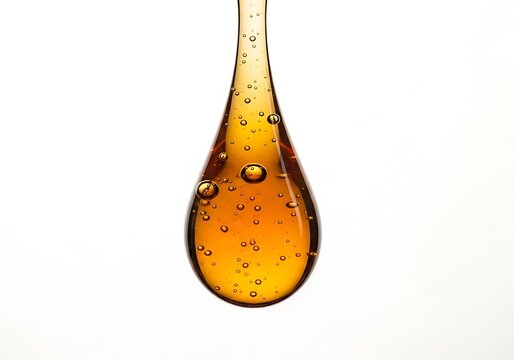 Close Up View Of Golden Liquid Droplet With Bubbles Isolated Against Clear Background