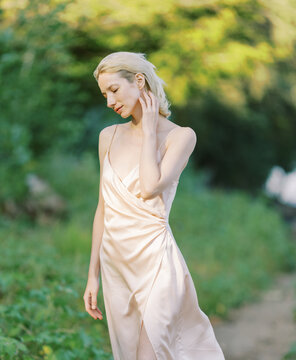 blond woman wearing silk classic dress outdoors