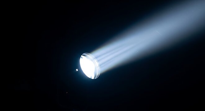 Bright white light beam emanates from a projector lens in darkness