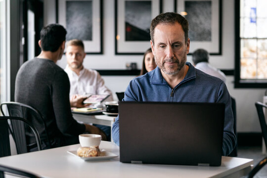 Business: Man Working Alone In Coffee House