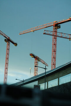 Metal cranes in city view from the car windshields. 