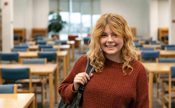 Happy Student In Library Looking At Camera