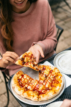 Dining: Woman Pulls A Slice Of Barbecue Pizza