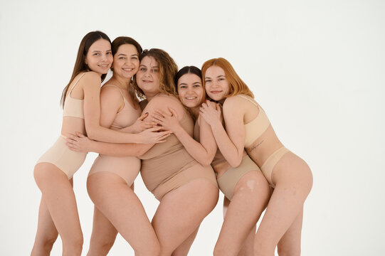 Group of diverse laughing women posing in the studio