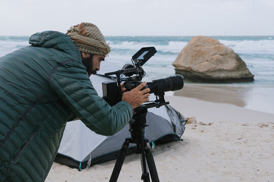 Filmmaker Capturing Footage on a Remote Beach
