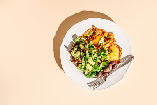 Mediterranean breakfast plate with eggs, salad, olives