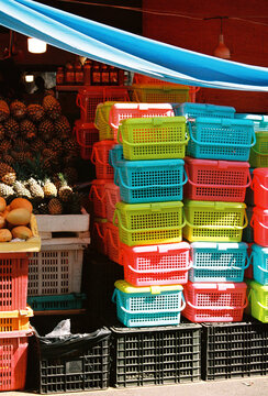 Stacked colorful plastic baskets at fruit market  