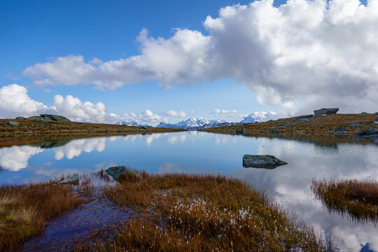 Alpine tarn reflecting clouds near Aletsch glacier, Swiss Alps