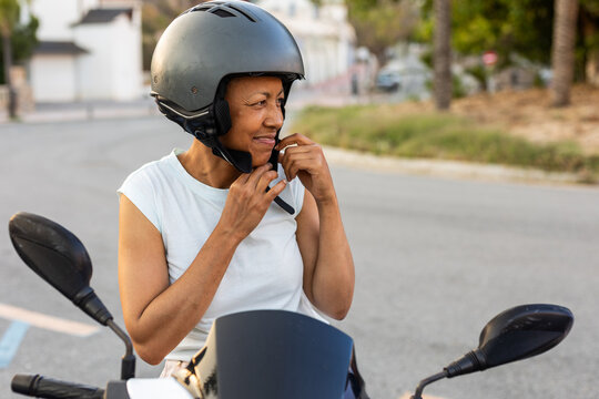 a woman putting on a helmet
