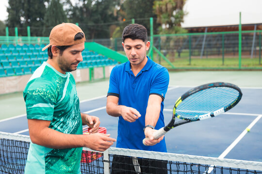 Tennis Coach Instructing Young Player on Grip Technique