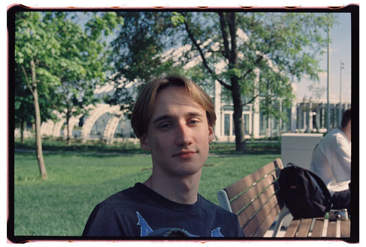 Young Blonde Guy With Earring Sitting in Park, Film Portrait