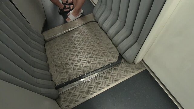 Close-up cinematic footage of the flexible connector between train carriages, showing smooth articulated movement as the train travels. This structural joint allows safe and continuous passage