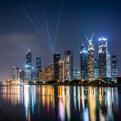 Obraz premium A vibrant night cityscape with tall illuminated buildings and their reflections in calm water, with light beams