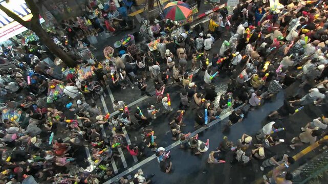 14 Aril 2026, Dynamic aerial footage capturing the vibrant atmosphere of the Songkran Festival along Silom Road in Bangkok, Thailand. Large crowds gather to celebrate with water guns
