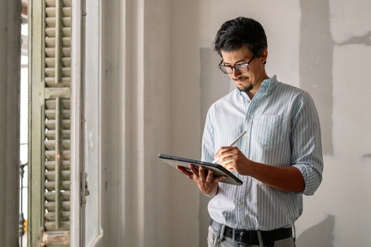 Architect Writing On Tablet