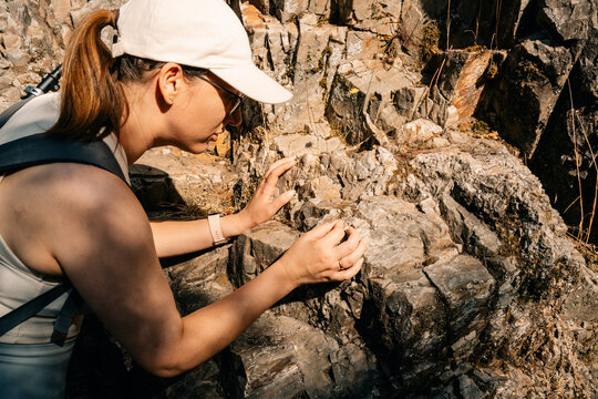 Exploring Rocky Terrain While Examining Geological Samples Outdoors