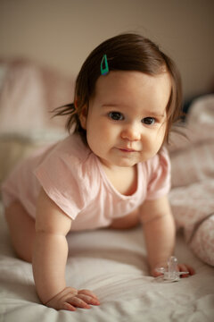 Smiling Baby Girl Crawling on Bed in Cozy Bedroom