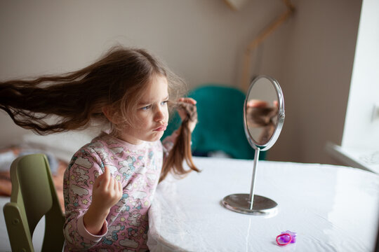 Little Girl Looking at Herself in Mirror at Home