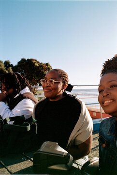 Friends hanging out at a bench near the beach