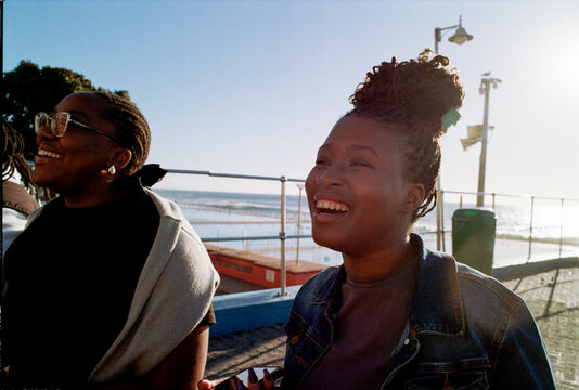 Friends laughing and smiling as the sun sets
