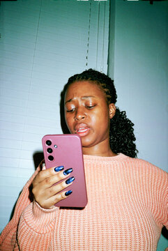 Woman using her phone in dim lighting